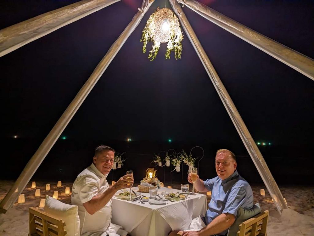 My partner and I at the beach dining table