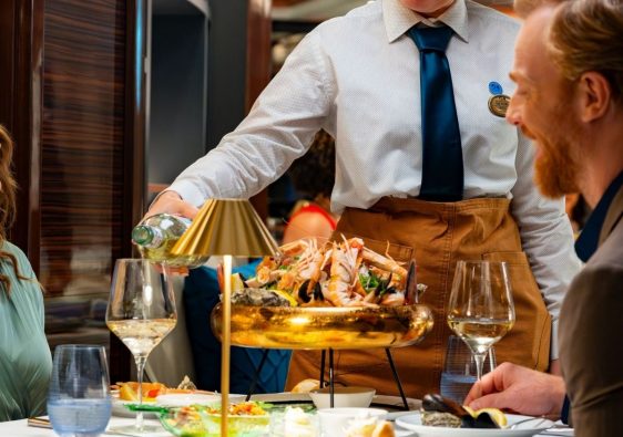 two people enjoying a meal in a restaurant on board the Enchanted Princess with their Princess Cruises package